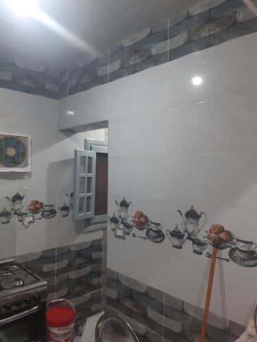 - une cuisine avec des plaques murales et une cuisinière dans l'établissement شقة فندقية فاخرة بدمياط قريبة من الميناء, à Dumyāţ al Jadīdah