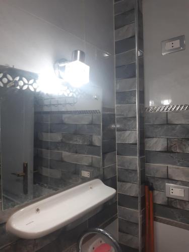 La salle de bains est pourvue d'un lavabo et d'un miroir. dans l'établissement شقة فندقية فاخرة بدمياط قريبة من الميناء, à Dumyāţ al Jadīdah
