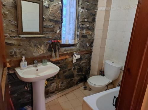 a bathroom with a sink and a toilet and a mirror at Cozy Mountain Villa in P. Agios Athanasios in Palaios Agios Athanasios
