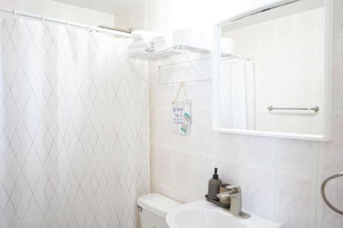 a bathroom with a toilet and a sink and a mirror at Ocean View, Playas del Caribe in Cabo Rojo