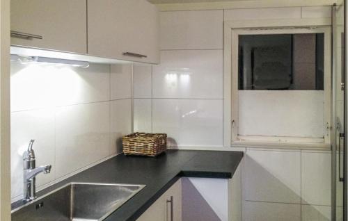 eine weiße Küche mit einem Waschbecken und einem Fenster in der Unterkunft 3 Bedroom Lovely Home In Mly in Måløy