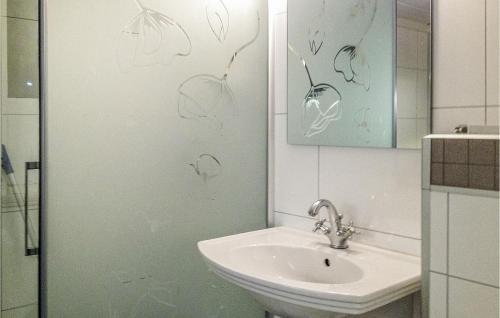 ein Badezimmer mit einem Waschbecken und einer Dusche mit Zeichnungen an der Wand in der Unterkunft 3 Bedroom Lovely Home In Mly in Måløy