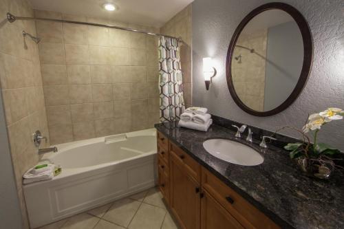a bathroom with a sink and a tub and a mirror at Holiday Inn Club Vacations At Orange Lake Resort, an IHG Hotel in Orlando