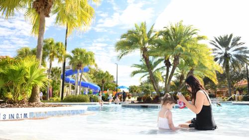 a woman and a child sitting in the water at a pool at Holiday Inn Club Vacations At Orange Lake Resort, an IHG Hotel in Orlando