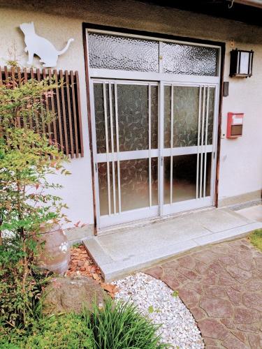 una porta con un gatto sul lato di una casa di Happy Neko a Beppu