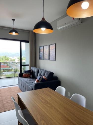 uma sala de estar com um sofá e uma mesa em Apartamento com vista mar completo em Governador Celso Ramos