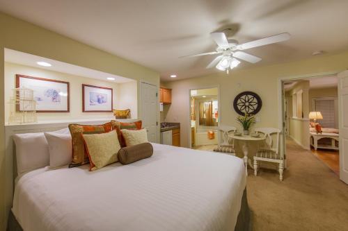 a bedroom with a white bed and a ceiling fan at Holiday Inn Club Vacations Holiday Hills Resort at Branson in Branson