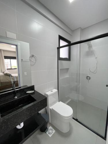 uma casa de banho com um WC, um lavatório e um chuveiro em Apartamento com vista mar completo em Governador Celso Ramos