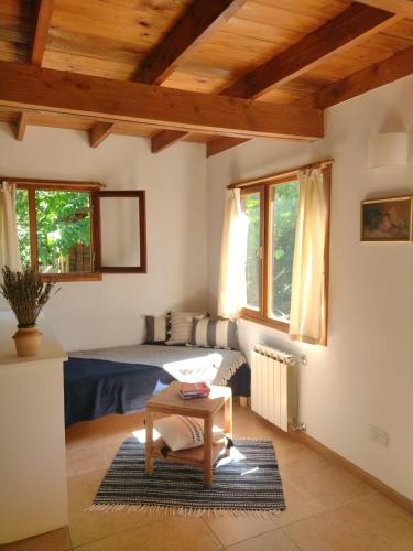 Sala de estar con cama y mesa en Cabañas El estribo sur Bariloche 3p en San Carlos de Bariloche