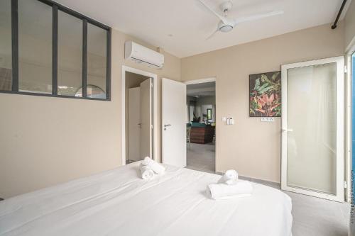 a bedroom with a white bed with two towels on it at Villa Maorie 5 chambres avec piscine privée in Le François