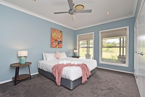 a bedroom with a large bed with blue walls at The Ponderosa on Merewether in Rothbury