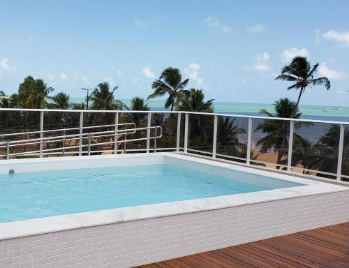uma piscina numa varanda com o oceano em Flat beira mar do Cabo Branco em João Pessoa