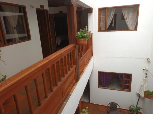 a stairway with two windows and a balcony with a potted plant at Cemandy Hostal in Villa de Leyva