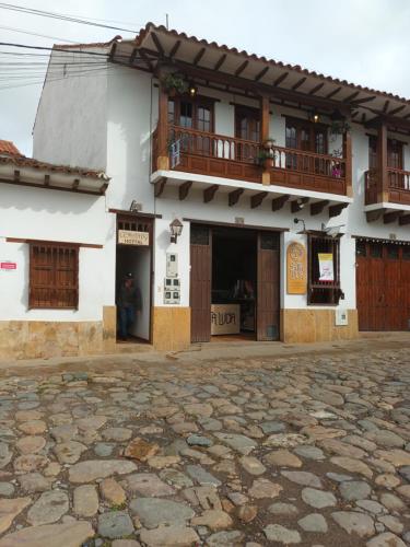 a building with two balconies on top of it at Cemandy Hostal in Villa de Leyva