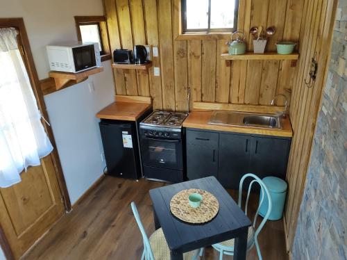 a small kitchen with a small table and a stove at El Encanto de Antilhue in Valdivia
