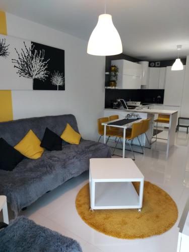 uma sala de estar com um sofá e uma mesa em Apartament Maxi em Poznań