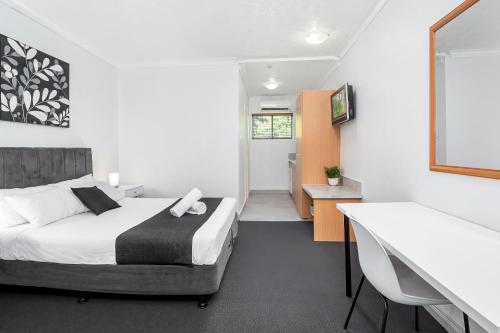 a bedroom with a bed and a desk and a sink at The Robert Towns in Townsville