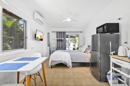 a kitchen with a bed and a refrigerator in a room at The Brick Batch - holiday unit! in Bellara
