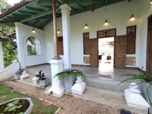a front porch of a house with wooden doors at Villa seven faces in Galle
