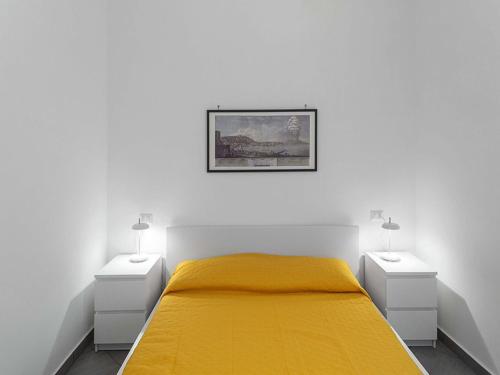 ナポリにあるBed & Breakfast Nilo32の白いベッドルーム(黄色のベッド1台、ナイトスタンド2台付)