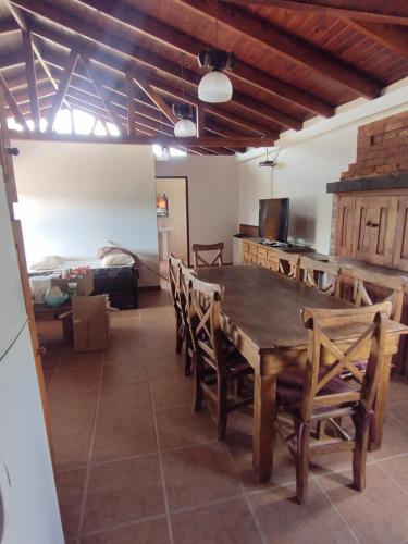 a dining room with a wooden table and chairs at FREEDOM Iris in Río Gallegos