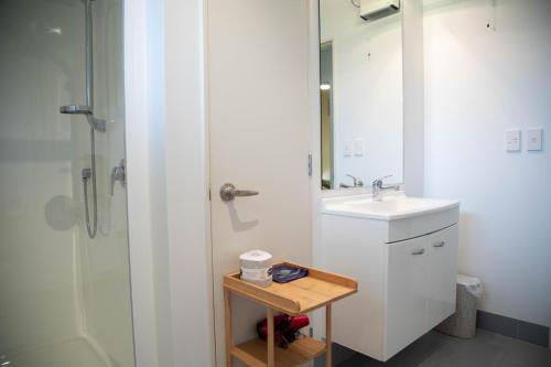 a white bathroom with a sink and a shower at Oceans 15 - Self-service Apartments in Whitianga