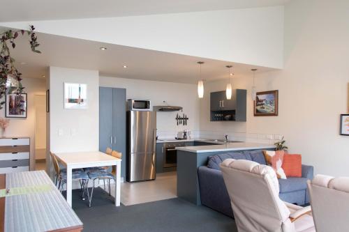 a kitchen and a living room with a couch and a table at Oceans 15 - Self-service Apartments in Whitianga