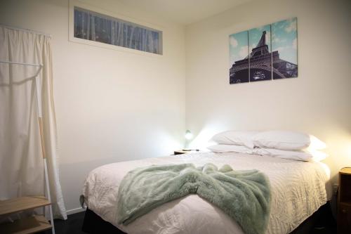 a bedroom with a bed with a blanket on it at Oceans 15 - Self-service Apartments in Whitianga