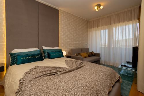 a bedroom with a large bed with blue pillows at Estúdio Encantador com vistas para o Douro Gaia in Vila Nova de Gaia
