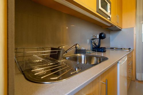 a kitchen with a sink and a dish rack on the counter at Estúdio Encantador com vistas para o Douro Gaia in Vila Nova de Gaia