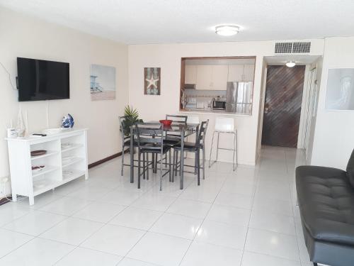a living room with a table and chairs and a kitchen at Coral Beach Isla Verde Beach Front Large 1 Bedroom Apt 208 Tower 1 in San Juan