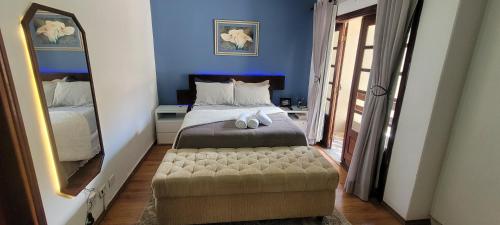 ein Schlafzimmer mit einem Bett und einem großen Spiegel in der Unterkunft Casa Próximo ao Centro Agradável e Inteligente in Poços de Caldas