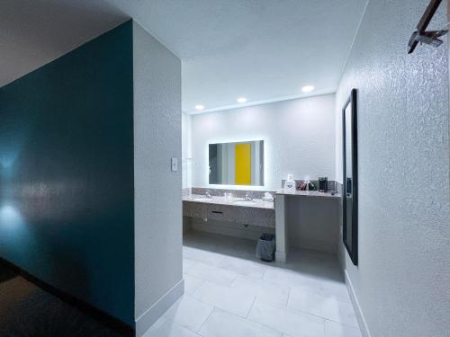 y baño con lavabo y espejo. en Days Inn & Suites by Wyndham Santa Rosa, NM en Santa Rosa