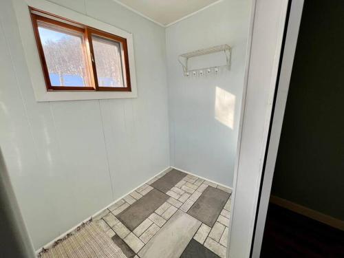 ein weißes Bad mit einem Fenster und einer Dusche in der Unterkunft Munising Getaway in Munising