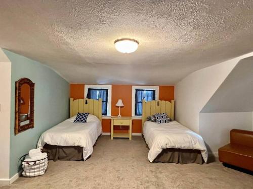 1 Schlafzimmer mit 2 Betten, einem Tisch und 2 Fenstern in der Unterkunft Munising Getaway in Munising