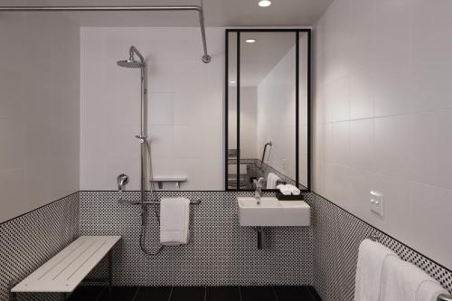 a bathroom with a sink and a mirror and a bench at Hotel X Brisbane Fortitude Vly, Vignette Collection by IHG in Brisbane