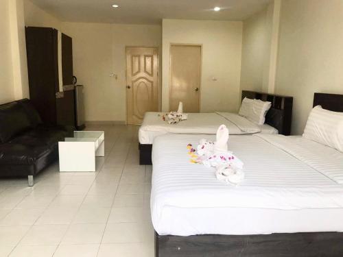 a hotel room with two beds with stuffed animals on them at Kata Beach Guesthouse in Kata Beach