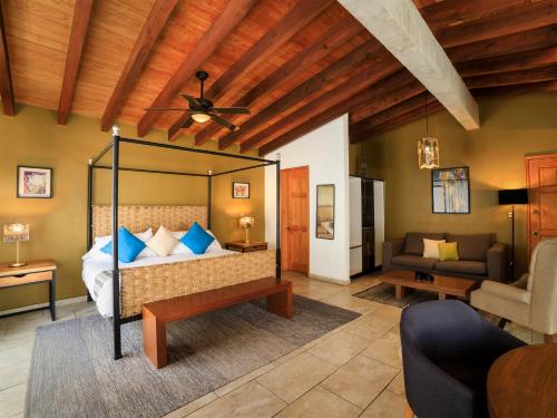 a bedroom with a bed and a living room at Hotel Amate del Rio in Malinalco