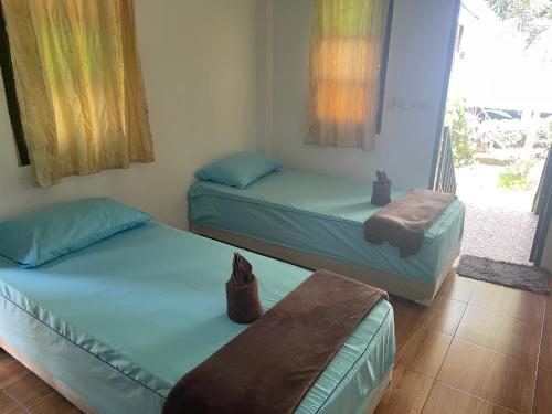 two twin beds in a room with a window at Lonely Beach Pool Resort in Ko Chang