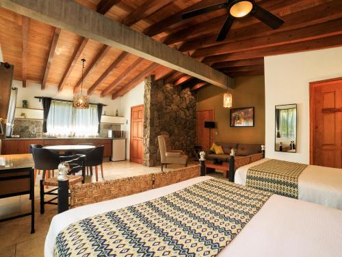 a hotel room with two beds and a desk at Hotel Amate del Rio in Malinalco