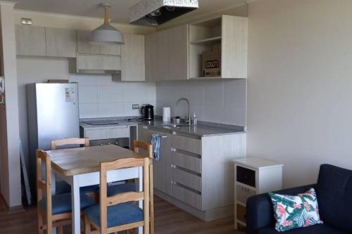 a small kitchen with a table and a refrigerator at Excelente ubicación in Valdivia