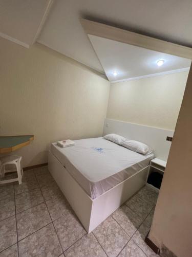 a small room with a bed and a desk at Hotel City II in Santo André