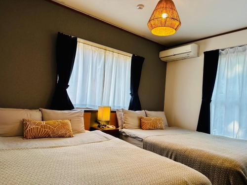 a room with two beds and a window at 熱海天海ヴィラ/ Atami Tenkai Villa in Atami