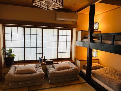 a room with two bunk beds and a window at 熱海天海ヴィラ/ Atami Tenkai Villa in Atami