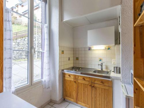 une petite cuisine avec un évier et une fenêtre dans l'établissement **Charmant logement à Cauterets avec balcon, proche des pistes et randonnées** - FR-1-401-253, à Cauterets