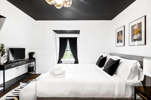 a bedroom with a white bed with a black ceiling at The Coach House in Salem