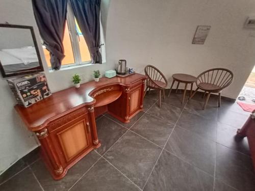 a wooden desk in a room with chairs at Monkey Mier LOT 2028 in Kampong Alor Gajah
