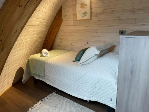 a bedroom with a bed in a wooden cabin at Domos Futronhue in Futrono
