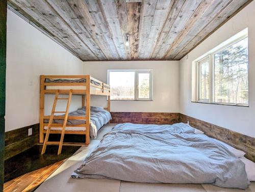 a bedroom with two beds and a wooden ceiling at 暮らす宿ソラプチ Sorapchi Cabin 