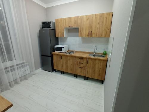 a small kitchen with a sink and a refrigerator at Апартаменты в ЖК Sat City на Левом берегу in Astana